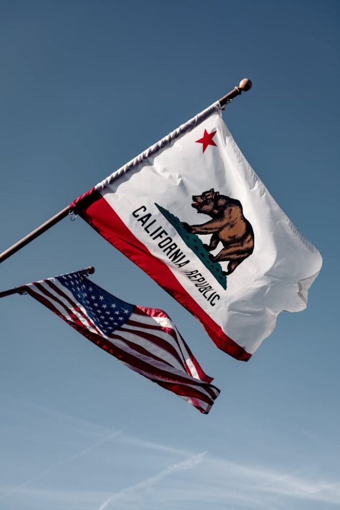 us-a-flag-under-blue-sky-3936201 California and US flags waving against a clear blue sky in Santa Barbara, embodying American patriotism.